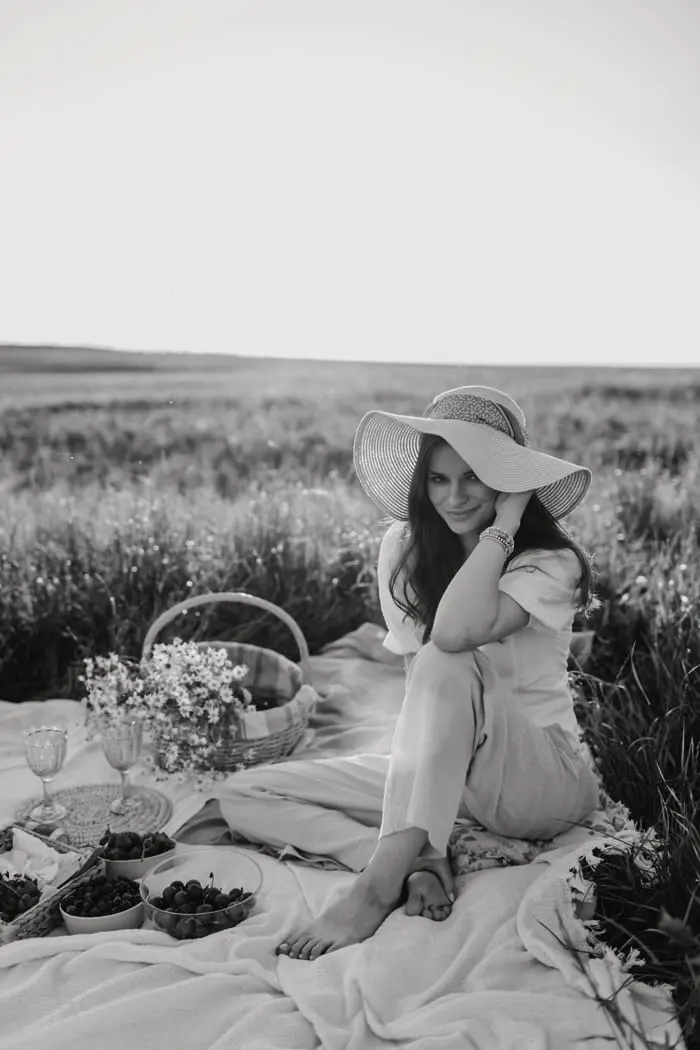 Renata con sombrero, sentada junto al picnic